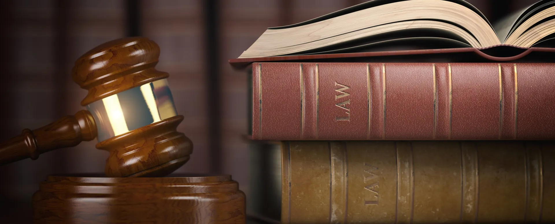 A gavel resting in front of a row of law books