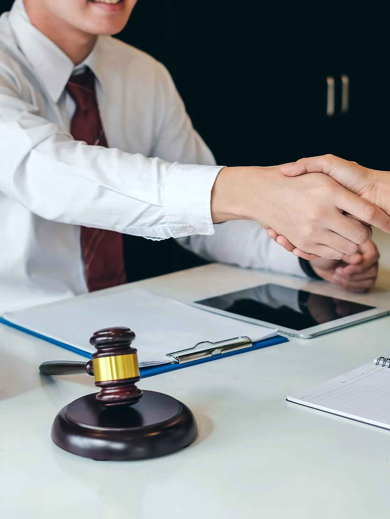 A lawyer shaking hands with a client across a desk