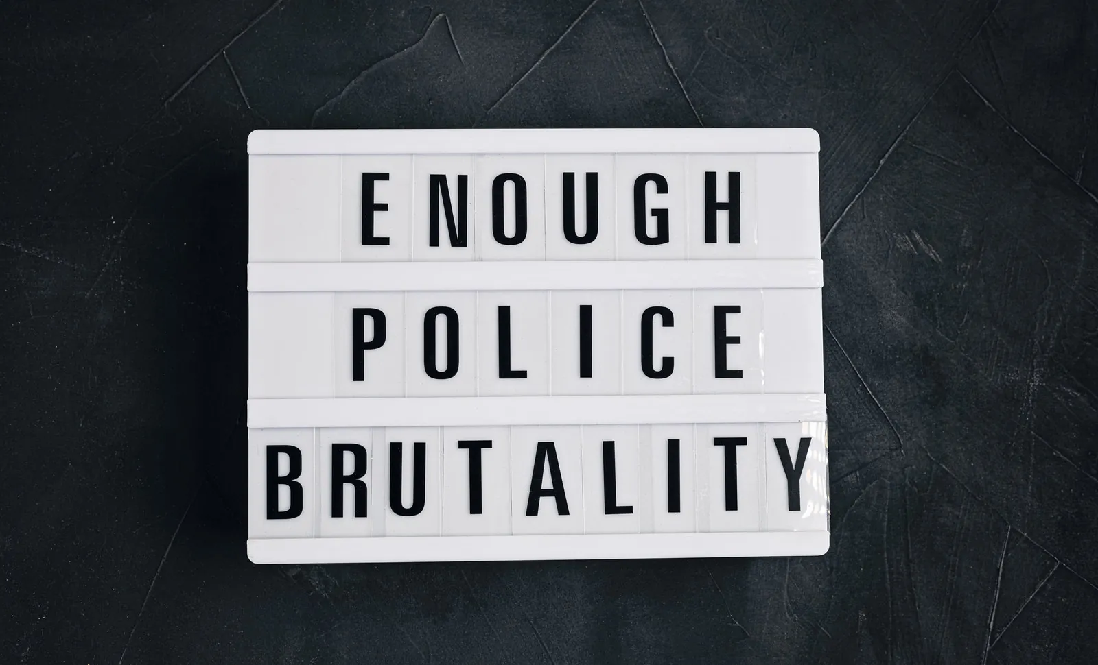 A light box spelling the words Enough Police Brutality